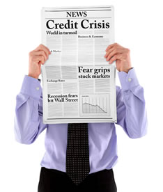 Man holding newspaper with economic headlines